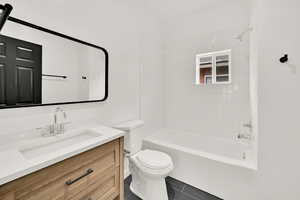 Full bathroom featuring vanity, tile patterned flooring, tiled shower / bath combo, and toilet