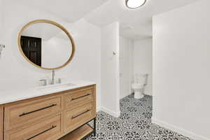 Bathroom with vanity, tile patterned floors, and toilet