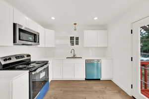 Kitchen with sink, stainless steel appliances, and white cabinets