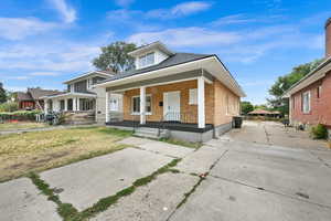 View of front of home with a porch and a front lawn. Before backyard fence was installed.