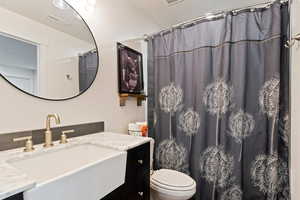 Jack-N-jILL Bathroom with vanity, toilet, and a shower with curtain