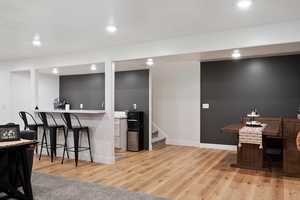 Basement Kitchenette with light hardwood / wood-style floors