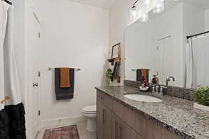 Main Level Bathroom with tile patterned flooring, vanity, and toilet