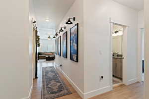 Corridor featuring a barn door, sink, a textured ceiling, and light hardwood / wood-style floors