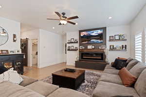 Living room with light hardwood / wood-style floors and ceiling fan