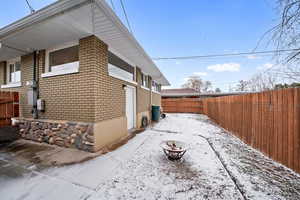 View of snowy exterior with an outdoor fire pit