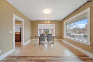 Dining room featuring sink, light tile patterned floors, a notable chandelier, and a textured ceiling