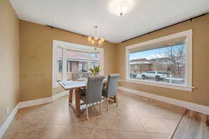 Tiled dining area featuring a notable chandelier