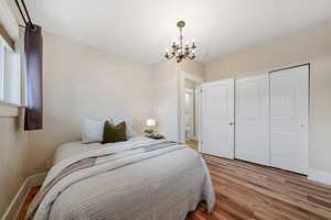 Bedroom featuring a chandelier, a closet, and light wood-type flooring