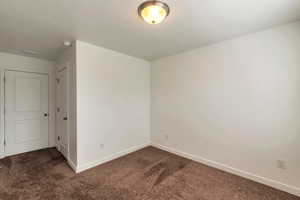 Carpeted spare room featuring a textured ceiling