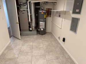 Utility room featuring secured water heater and electric panel