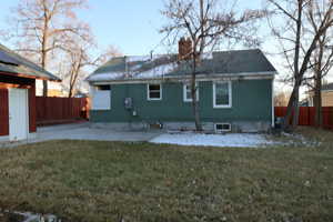 Rear view of house with a yard and a patio