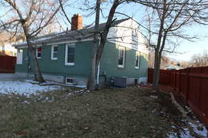 Snow covered property featuring a lawn and central air condition unit