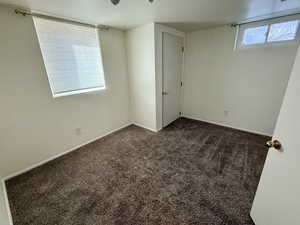 Spare room featuring dark carpet