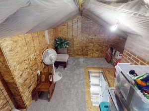 View of unfinished attic with pull down latter