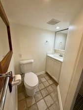 Bathroom with vanity, toilet, and a textured ceiling