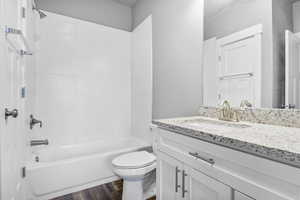 Full bathroom featuring vanity, LVP flooring, toilet, and tiled shower / bath