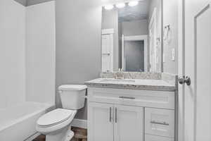 Full bathroom with LVP / wood-style flooring, vanity, shower / bathing tub combination, and toilet