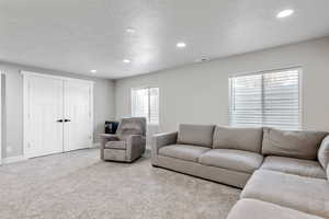 Living room featuring light carpet and a textured ceiling