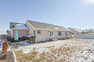 Snow covered property with a patio area