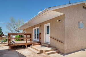 Entrance to property featuring a wooden deck and french doors