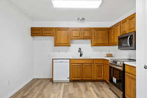 Kitchen with sink, stainless steel appliances, and light wood-type flooring