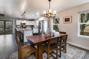 Dining space with dark hardwood / wood-style flooring, sink, and a chandelier