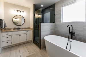 Bathroom featuring shower with separate bathtub, vanity, and a textured ceiling