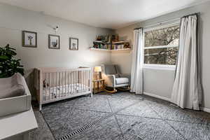 Unfurnished bedroom with carpet and a crib