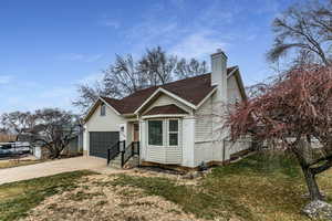 View of front facade featuring a garage and a front lawn