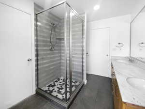 Bathroom with tile patterned flooring, vanity, and walk in shower