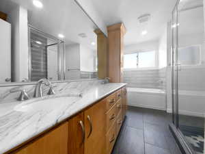 Bathroom with tile patterned floors, vanity, and separate shower and tub