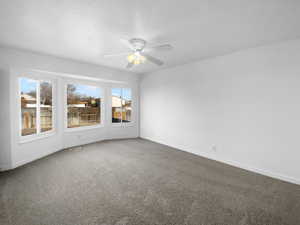 Carpeted empty room featuring ceiling fan