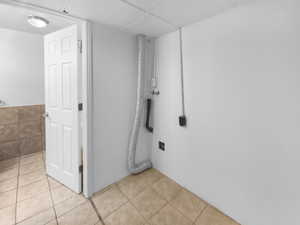 Bathroom featuring tile patterned flooring and a paneled ceiling