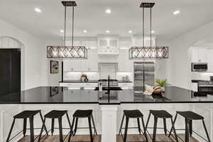 Kitchen featuring beautiful appliances, large island and contemporary lighting.