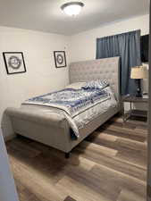 Bedroom with wood-type flooring and a textured ceiling