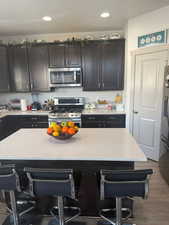 Kitchen featuring a center island, a kitchen bar, stainless steel appliances, and tasteful backsplash