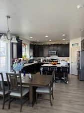 Dining area featuring sink, wood-type flooring, and a textured ceiling