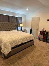 Carpeted bedroom featuring lofted ceiling