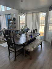 Dining room with wood-type flooring, a textured ceiling, and a chandelier