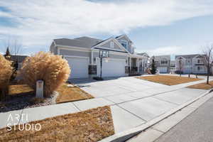 View of front of home with concrete driveway, an attached garage, and a residential view