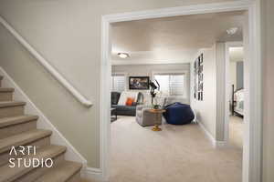 Stairs with carpet, baseboards, and a textured ceiling