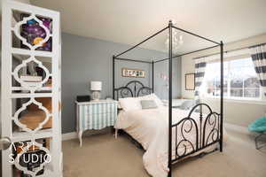 Bedroom with a chandelier, carpet flooring, and baseboards