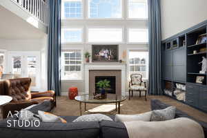 Carpeted living room with a high ceiling, a fireplace, and baseboards