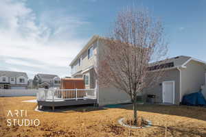 Back of property with a deck, fence, a yard, a residential view, and stucco siding