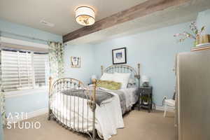 Bedroom featuring a textured ceiling, light colored carpet, visible vents, baseboards, and beamed ceiling