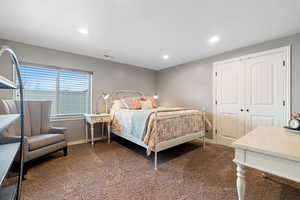 Bedroom with dark colored carpet and a closet