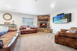 Living room featuring a stone fireplace and carpet floors