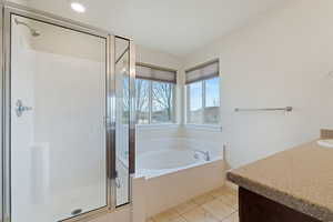 Bathroom with independent shower and bath, vanity, and tile patterned floors