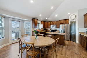 Dining area featuring vaulted ceiling, sink, and hardwood / wood-style floors